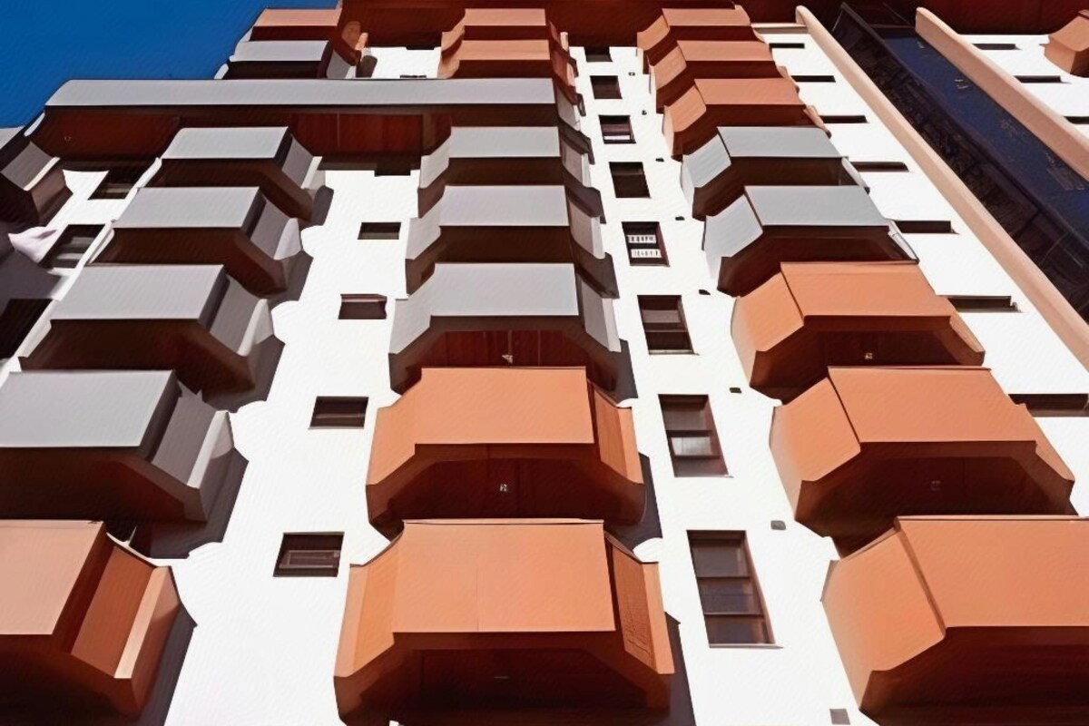 Um edifício alto com várias varandas e janelas.