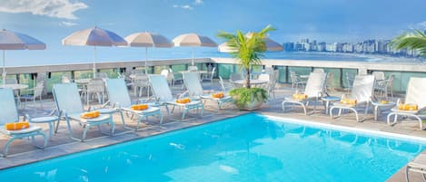 Piscine extérieure, parasols de plage, chaises longues