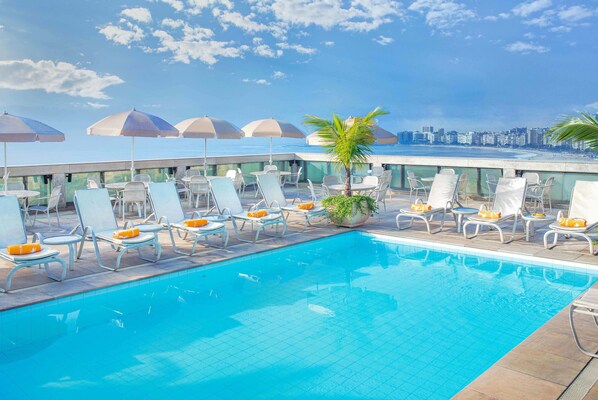 Piscine extérieure, parasols de plage, chaises longues