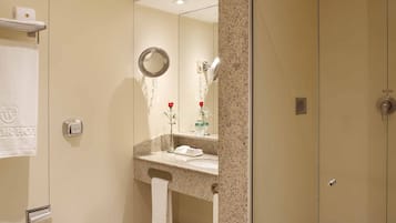 A modern bathroom with a toilet, bidet, and a glass-enclosed shower.