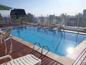 Una piscina al aire libre, sombrillas, tumbonas