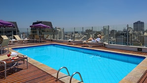 A rooftop pool with clear blue water, surrounded by wooden deck and lounge chairs. - Mercure Sao Paulo Alamedas (São Paulo)