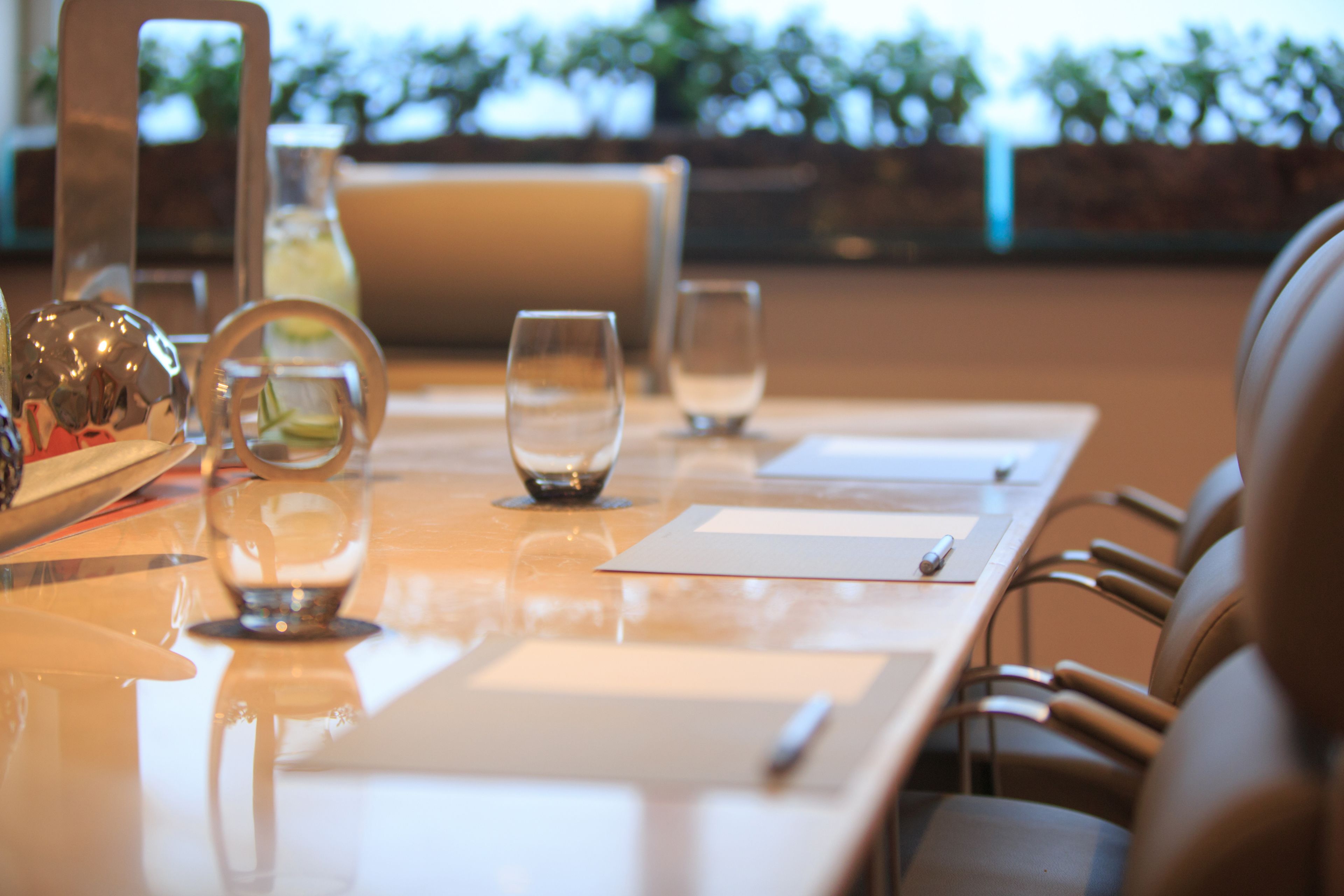 Una mesa de comedor con cristalería transparente, una botella y un menú.
