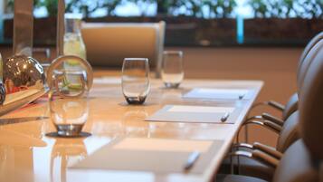 Una mesa de comedor con cristalería transparente, una botella y un menú.