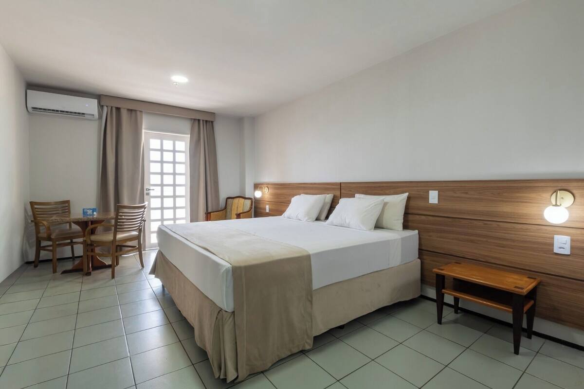 A hotel room with a bed, a desk, and a chair.