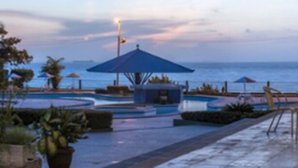 A pool area with umbrellas and chairs, overlooking the sea. - Hotel Resort Rio Poty (São Luís)
