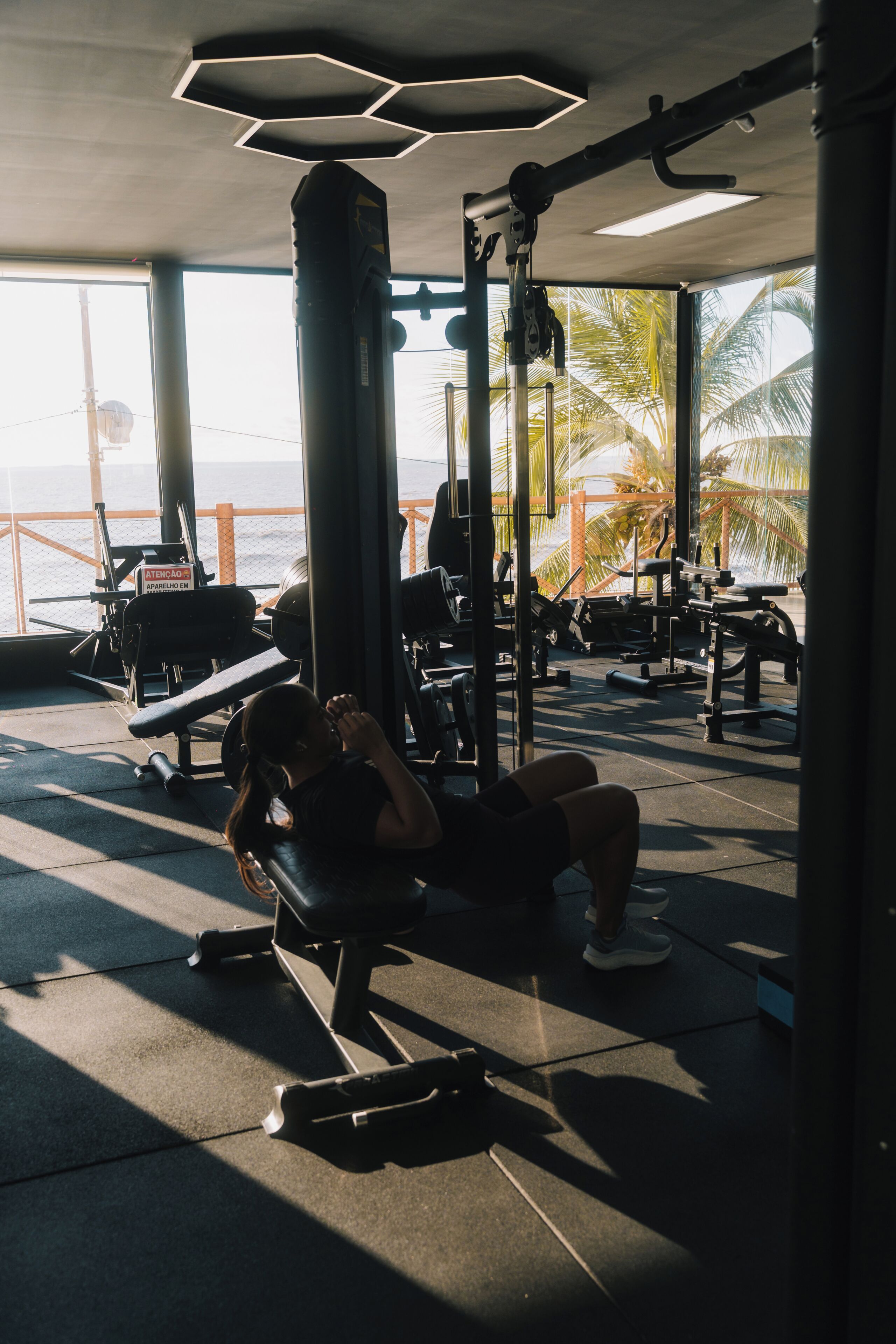 A gym with exercise equipment and a view of the ocean.