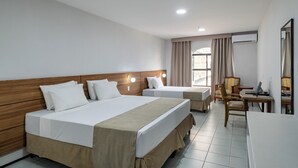 A hotel room with two beds, a desk, a chair, and an air conditioning unit. - Hotel Resort Rio Poty (São Luís)