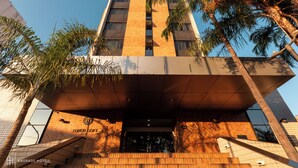 Una entrada de hotel moderna con un letrero destacado que dice 'LUXOR SOFT HOTEL' y 'ANDRADE HOTELS'.