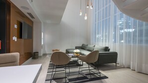A modern living room with a sofa, two armchairs, a coffee table, and a TV mounted on the wall. - 45 by Director (Santiago)