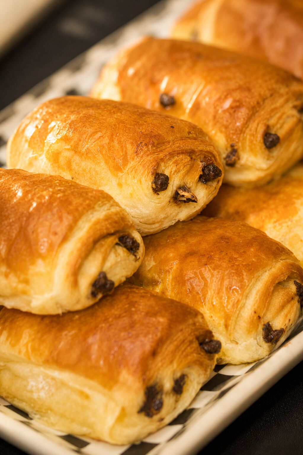 A tray of golden-brown pastries with visible chocolate chips.
