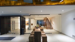 A modern interior with a central wooden table, benches, a staircase, and a glass partition. - 45 by Director (Santiago)