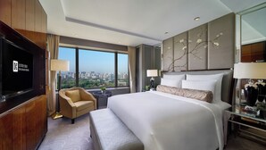 A hotel room with a large bed, a television, a sofa, and a city view. - The Kunlun Beijing (Beijing)