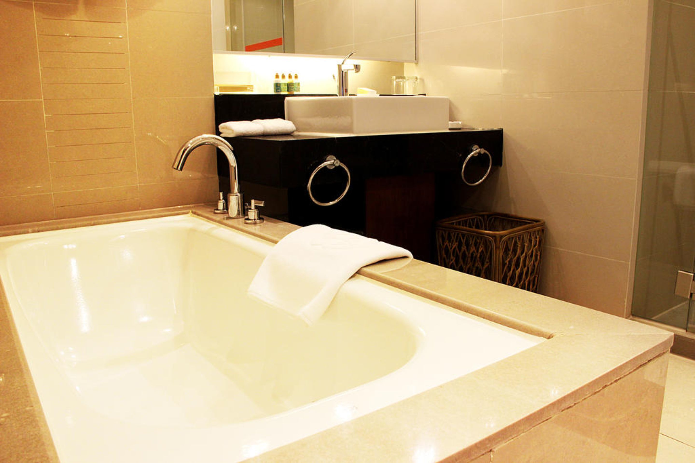 Un baño moderno con una bañera grande, un lavamanos y un espejo sobre el mueble.