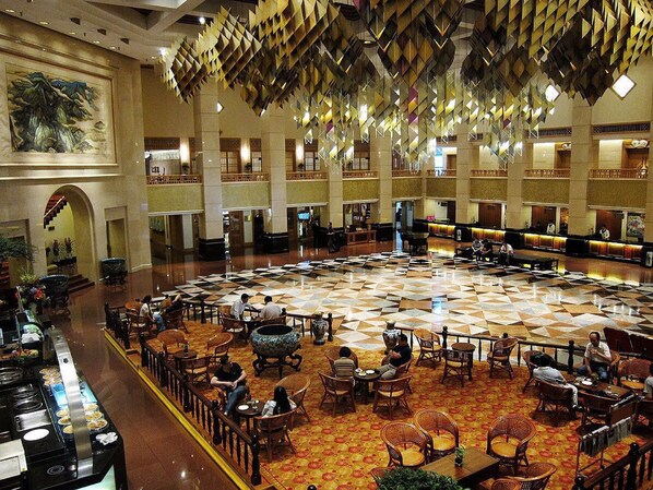 A spacious lobby with a checkered floor, multiple seating areas, and a large decorative ceiling. - Xiyuan Hotel (Beijing)