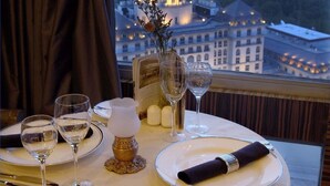 Une table dressée pour le dîner, avec une vue sur la ville en arrière-plan.