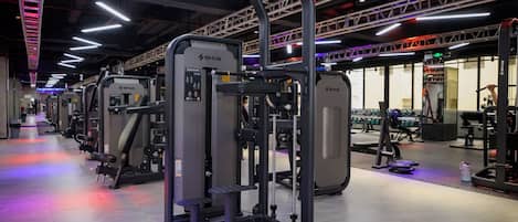 Une salle de sport équipée de divers appareils d’entraînement, notamment un support à squats et un appareil pour les exercices de développé couché.
