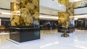 Un'ampia hall con soffitti alti e grandi pannelli murali floreali.