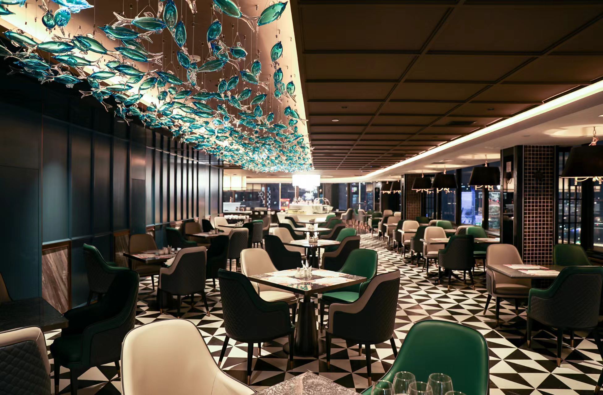 A restaurant with a geometric patterned floor, modern furniture, and a large decorative ceiling installation.