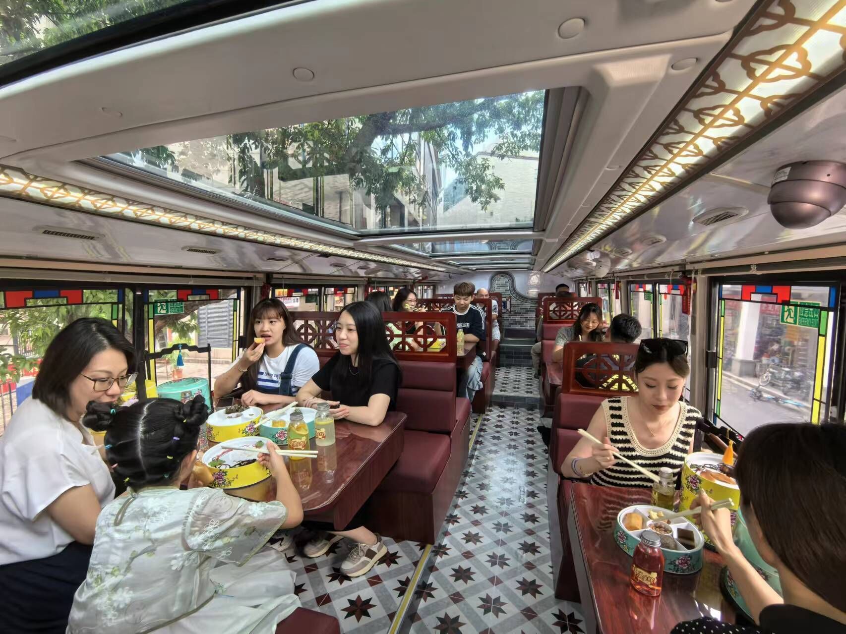 Un wagon-restaurant d’un train, où des passagers sont assis à des tables et savourent leurs repas.