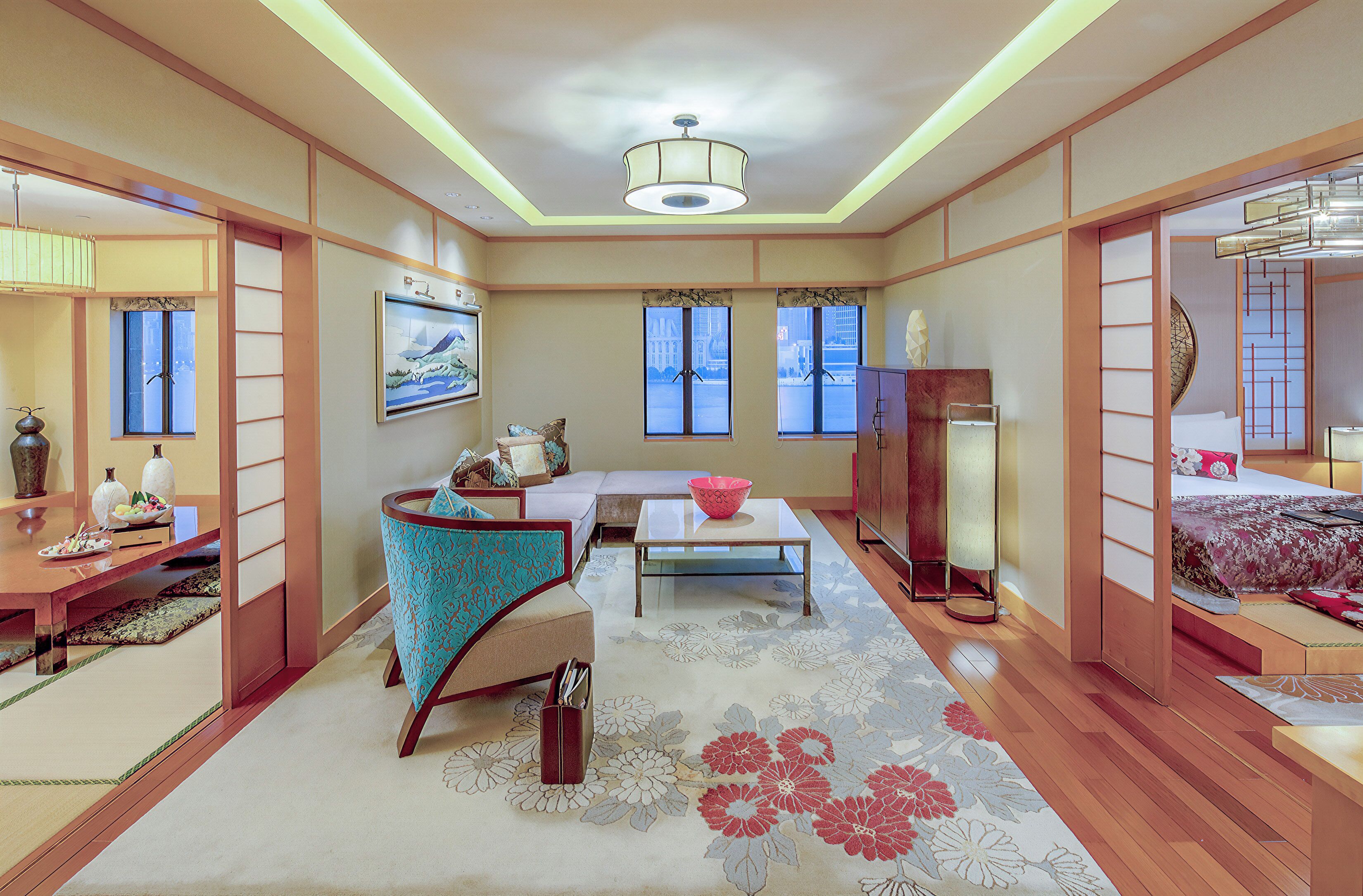 A traditional Japanese-style room with tatami flooring, a low table, a sofa, and sliding doors.