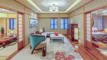 A traditional Japanese-style room with tatami flooring, a low table, a sofa, and sliding doors.