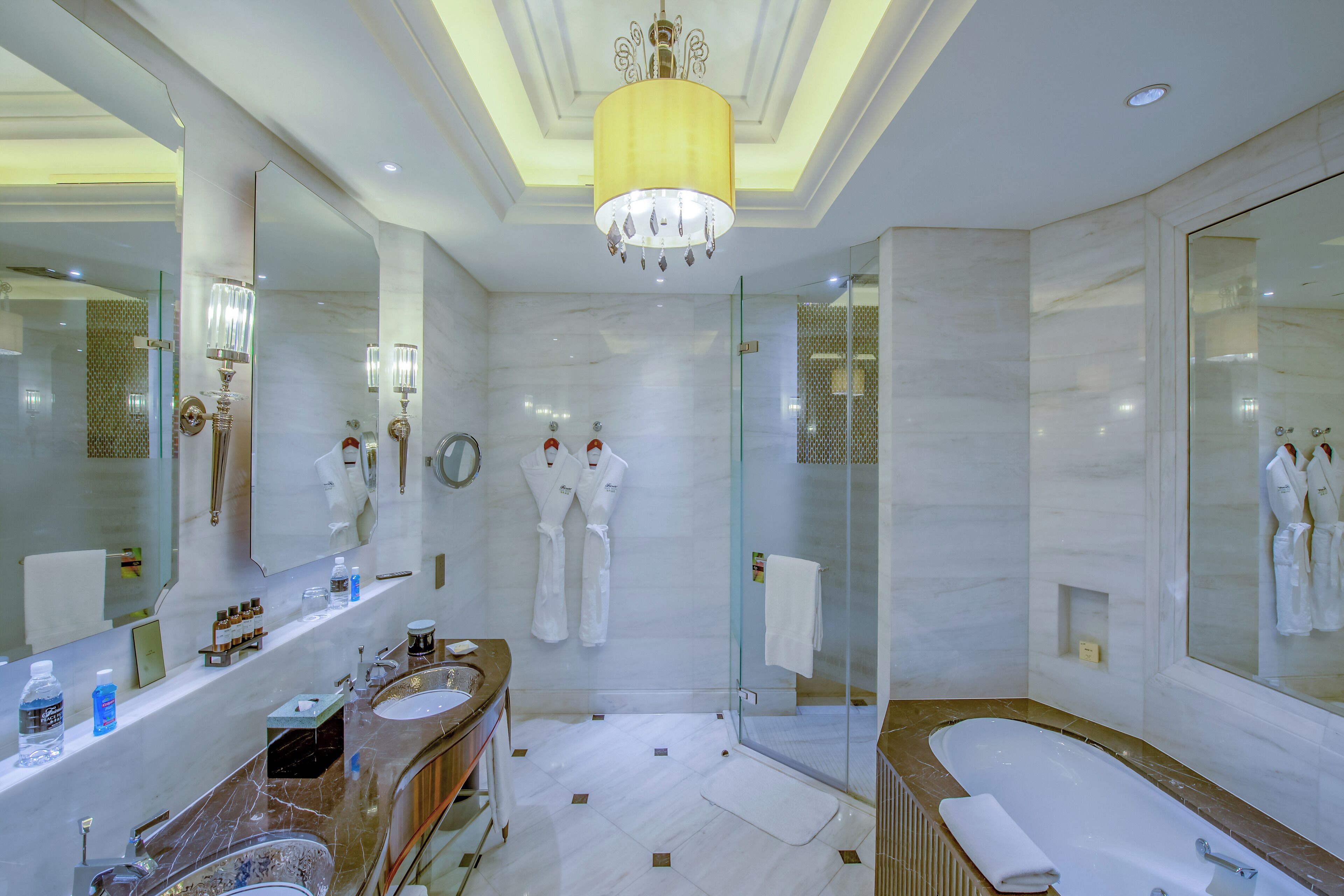 A modern bathroom with a large mirror, a bathtub, and a glass shower enclosure.