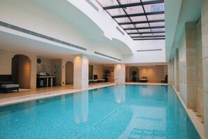 Una piscina techada, sillones reclinables de piscina