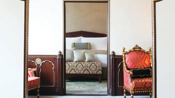 Una habitación con un espejo grande que refleja una cama, una silla y un piso alfombrado.