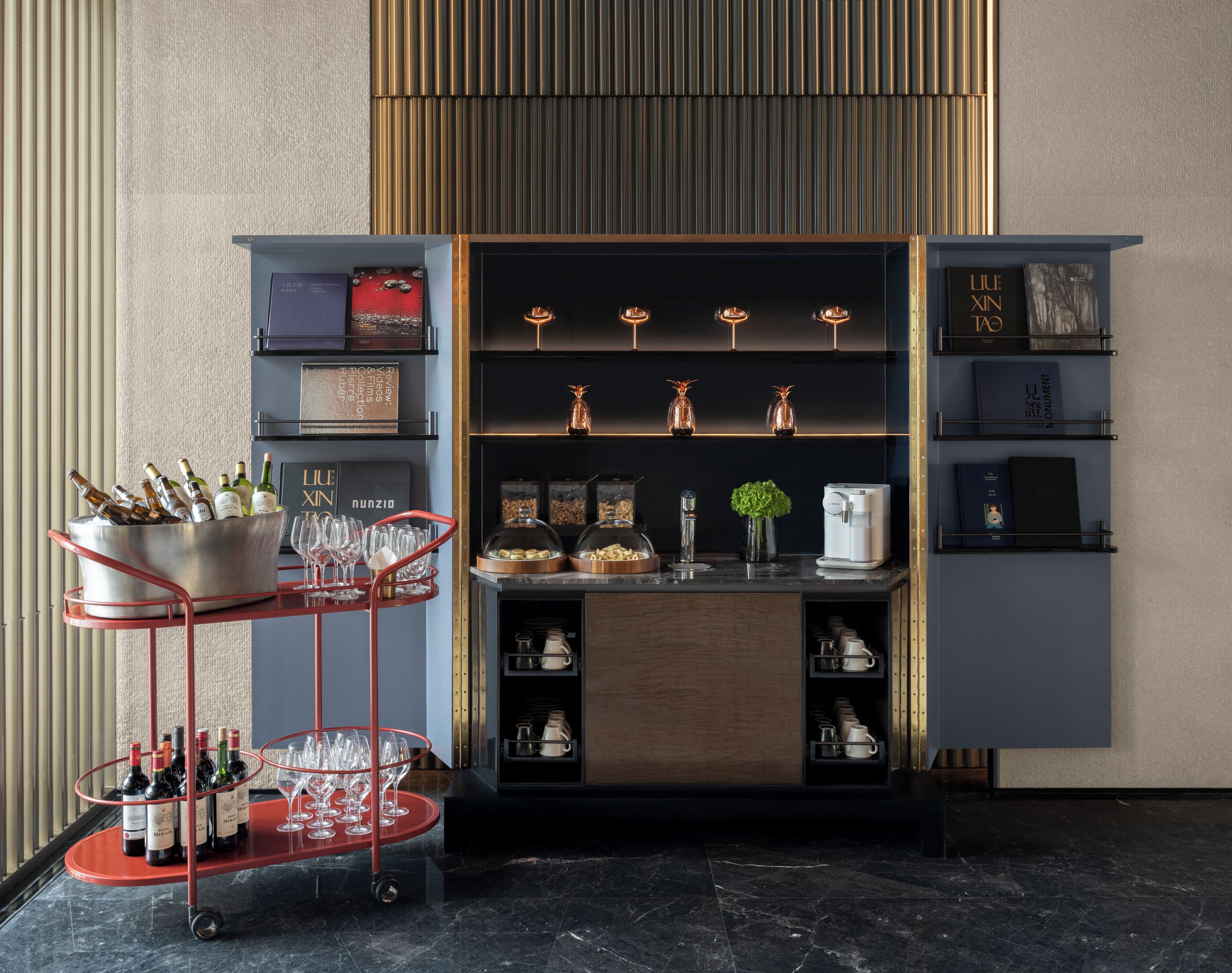 A modern bar area with a wine cooler, glasses, and a coffee machine.