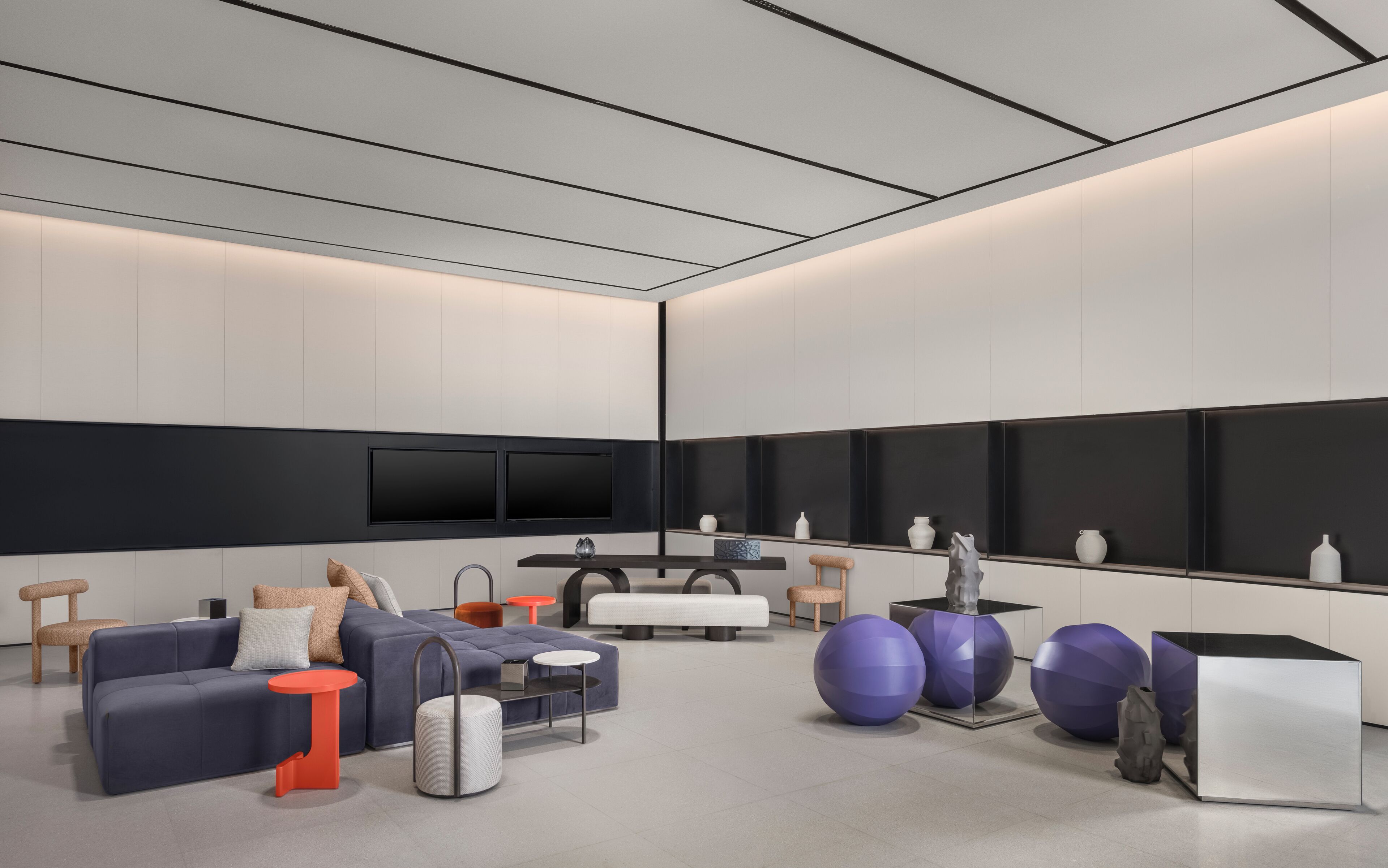 Una sala de estar moderna con sofá, reposapiés, mesa de centro y objetos decorativos.
