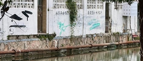 A building with graffiti and a water body in front.