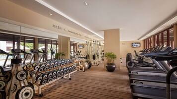 A gym with treadmills, elliptical machines, and weightlifting equipment.