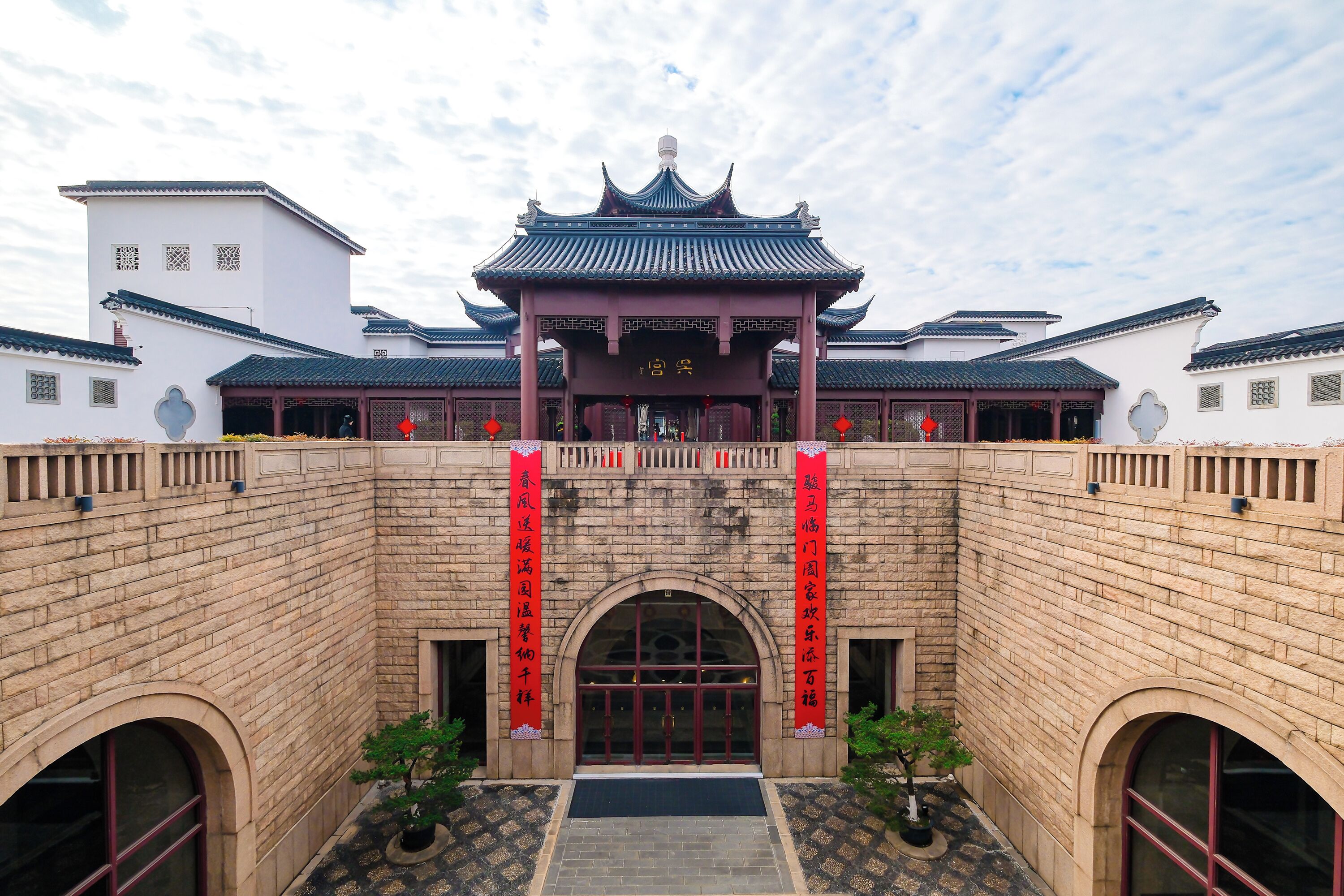A traditional Chinese building with a tiled roof and a central pavilion.
