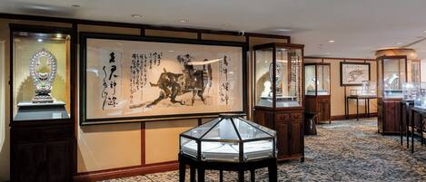 Une pièce de style japonais traditionnel, avec un sol recouvert de tatamis, un paravent shoji et des œuvres d’art calligraphique.