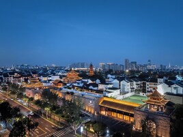 Un complejo arquitectónico tradicional chino con varios edificios de estilo pagoda, rodeado por modernos rascacielos.