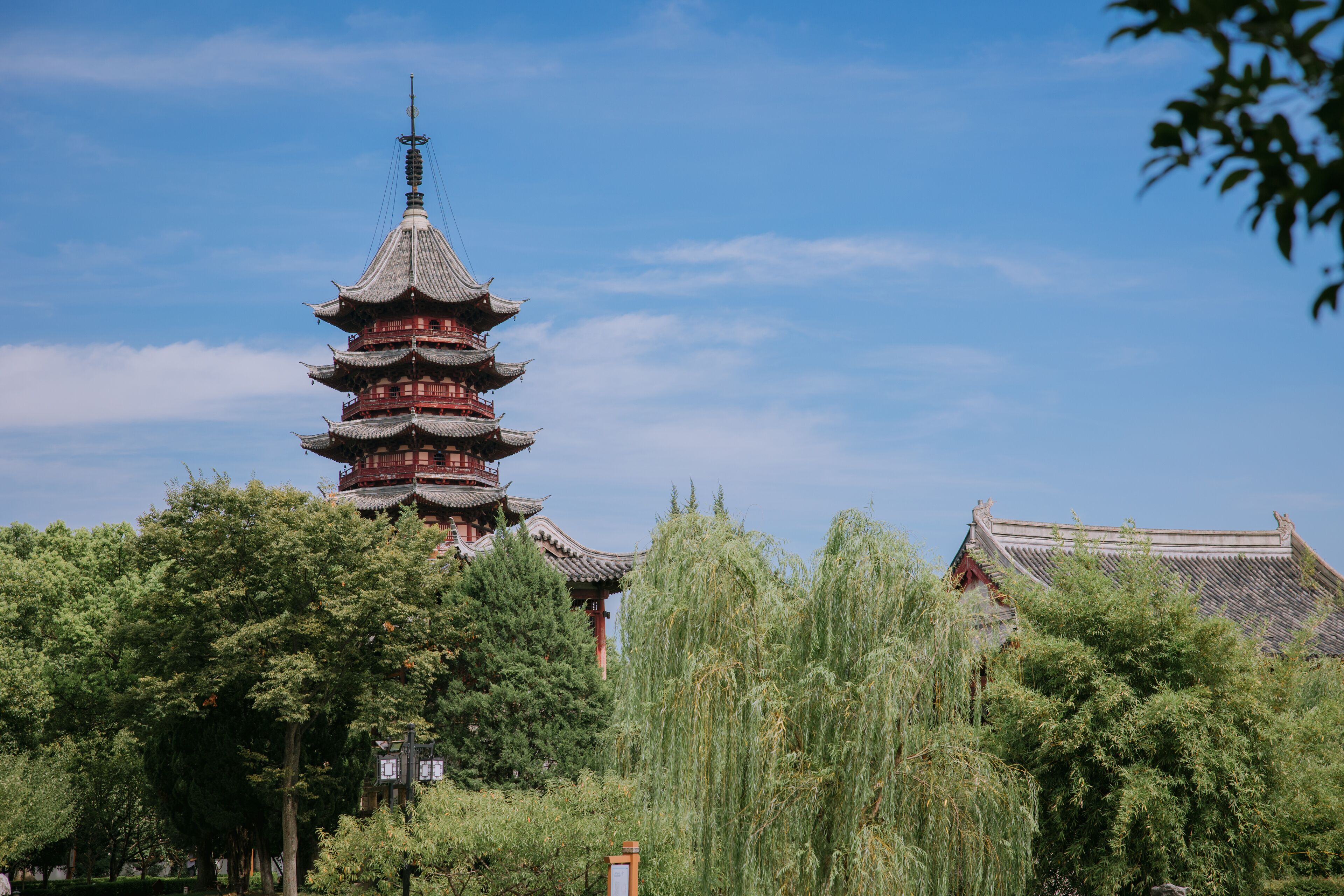 A traditional pagoda with multiple tiers, surrounded by lush greenery and trees.