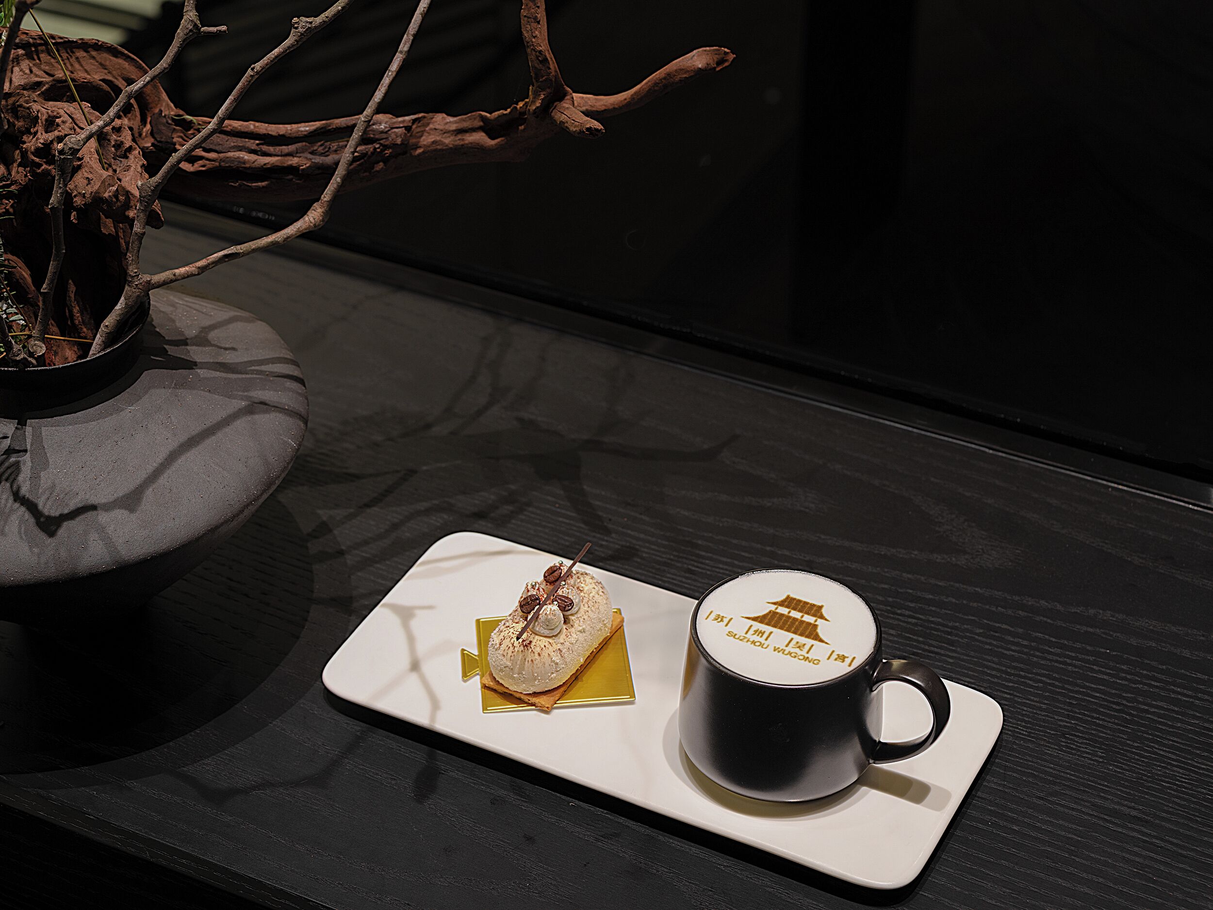 A tray with a dessert and a mug on a dark wooden table.