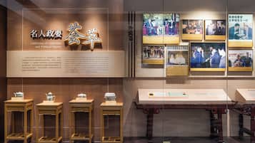 A museum exhibit with a sign reading "Gathering of Celebrities and Political Figures" and several framed photographs on the wall.