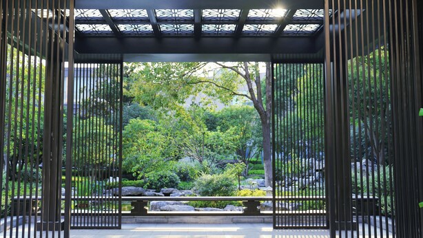 A traditional Japanese garden with a wooden gate, stone pathway, and lush greenery. - Holiday Inn Express Zhengzhou by IHG (Zhengzhou)