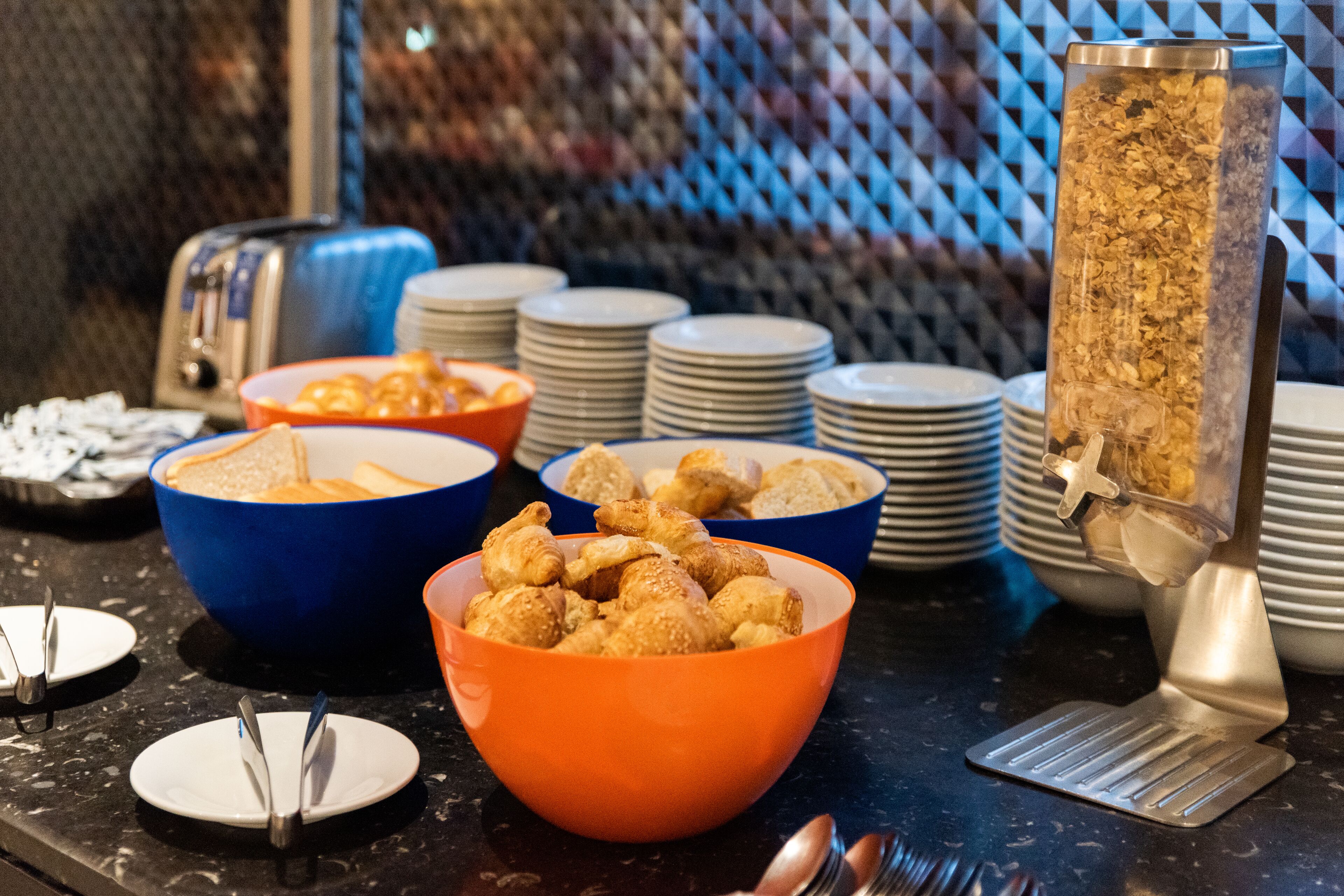 A buffet setup with various food items and serving utensils.