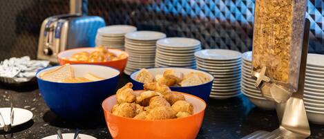 Una mesa de buffet con diferentes alimentos y utensilios de servicio.