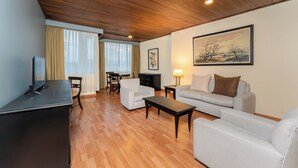 Una sala de estar con techo de madera, un sofá, una mesa de centro, un televisor y un cuadro en la pared.