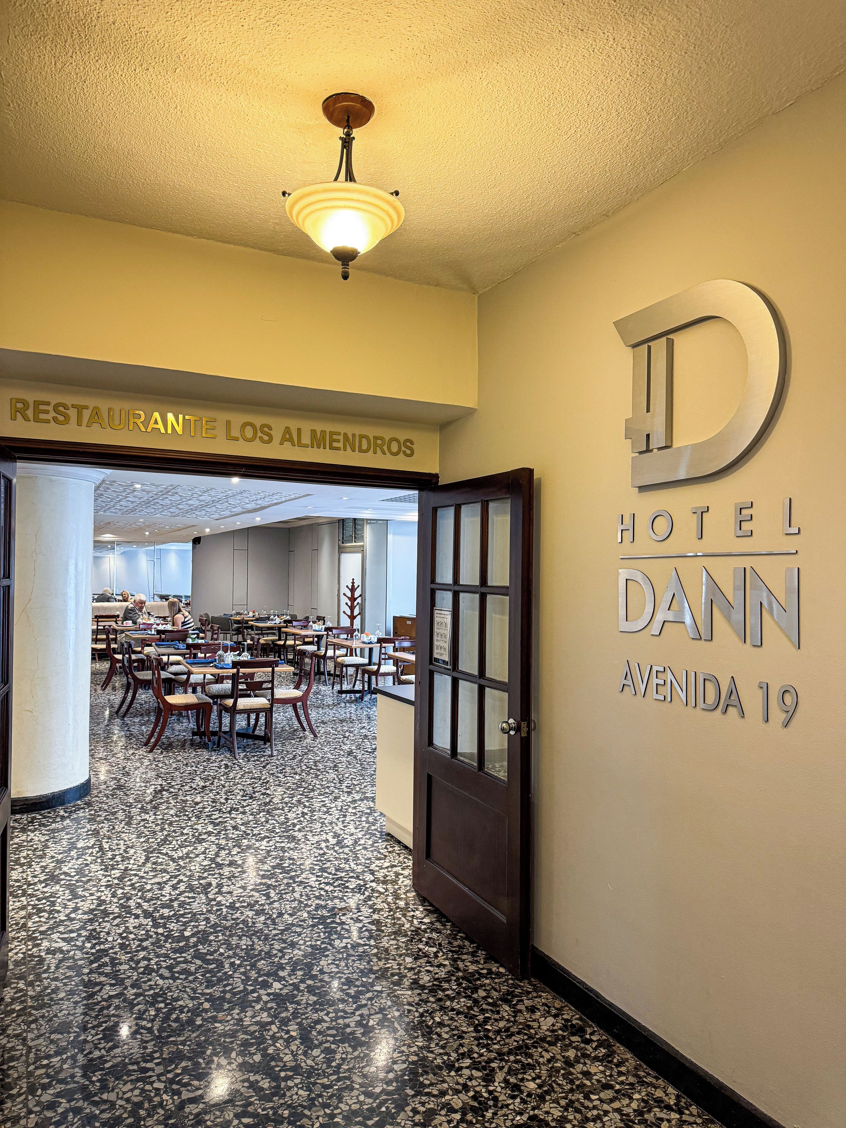 A hotel lobby with a sign for 'Hotel Dann Avenida 19'.