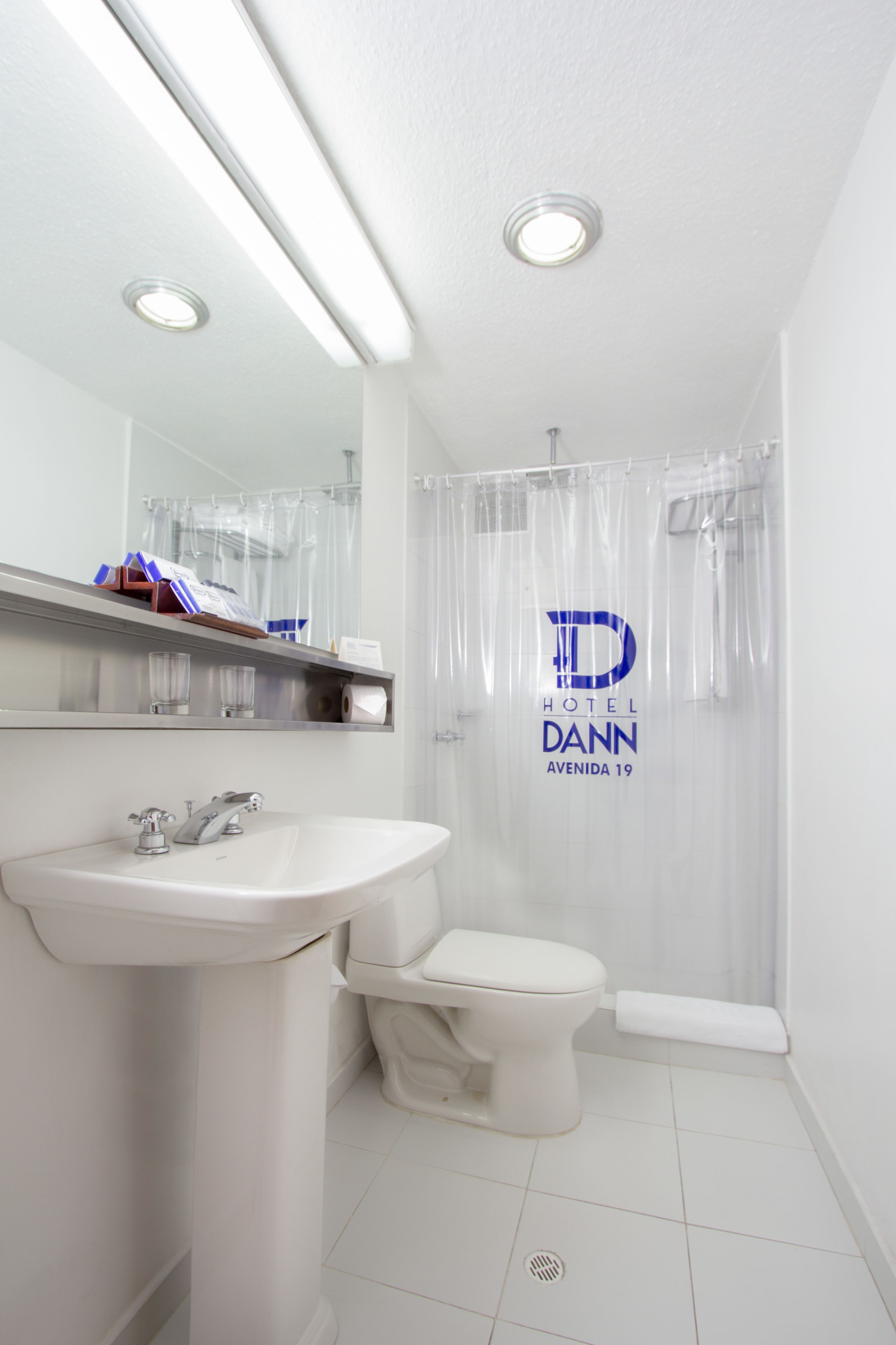A modern bathroom with a sink, toilet, and shower curtain.
