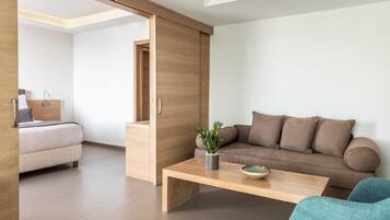 Een moderne woonkamer met een bank, een bijzettafeltje en een blauwe fauteuil.
