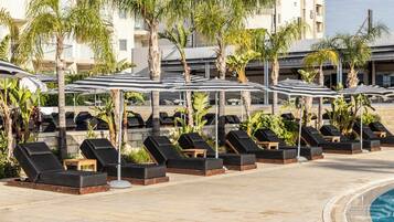 Relax by the pool with comfortable sun loungers and umbrellas providing shade.