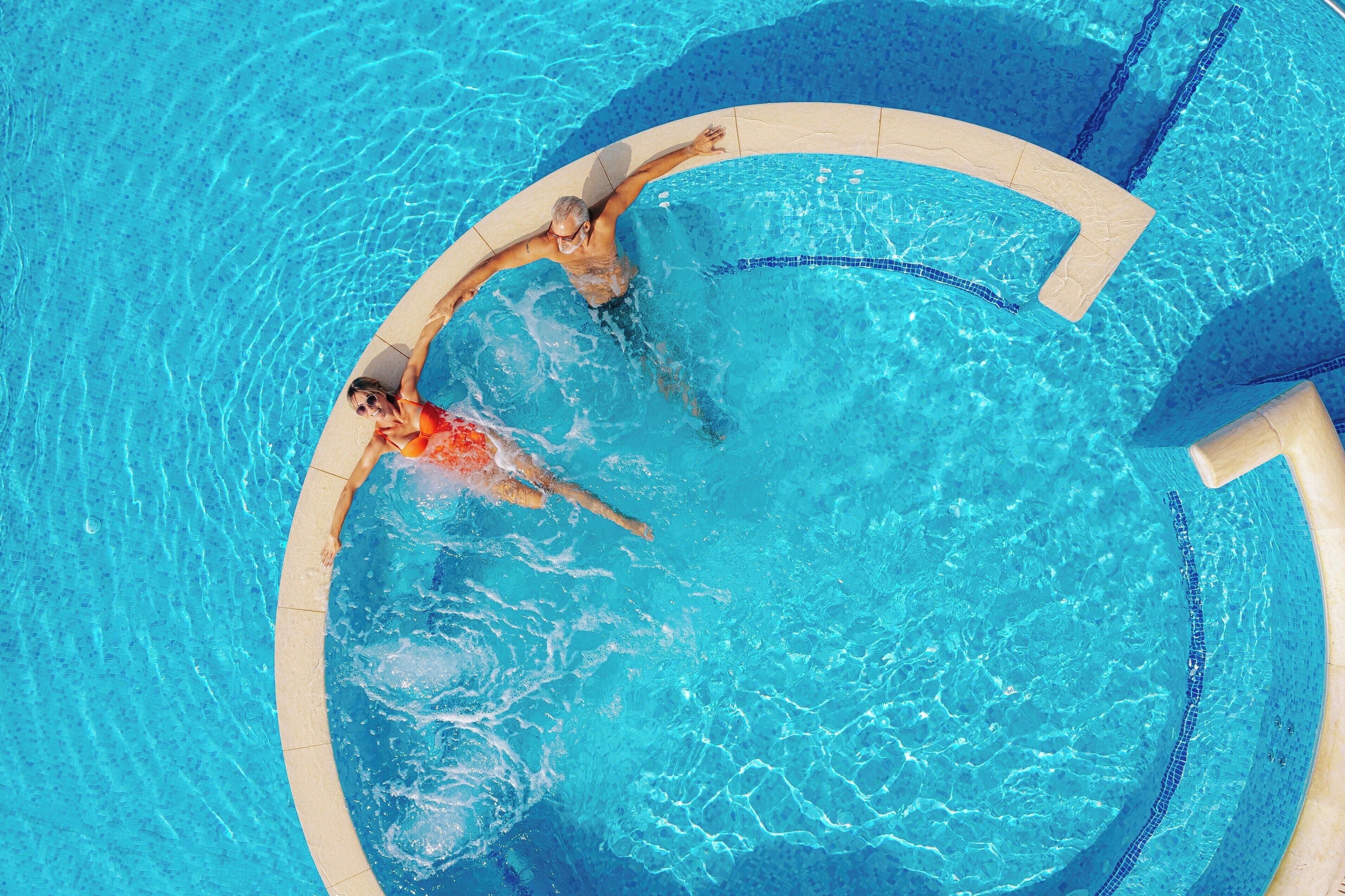 Una piscina circular con agua azul cristalina y borde de azulejos.
