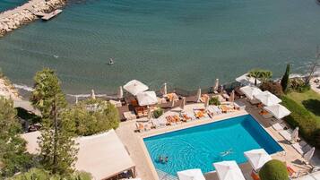 Alberca al aire libre, sombrillas en la alberca y camastros