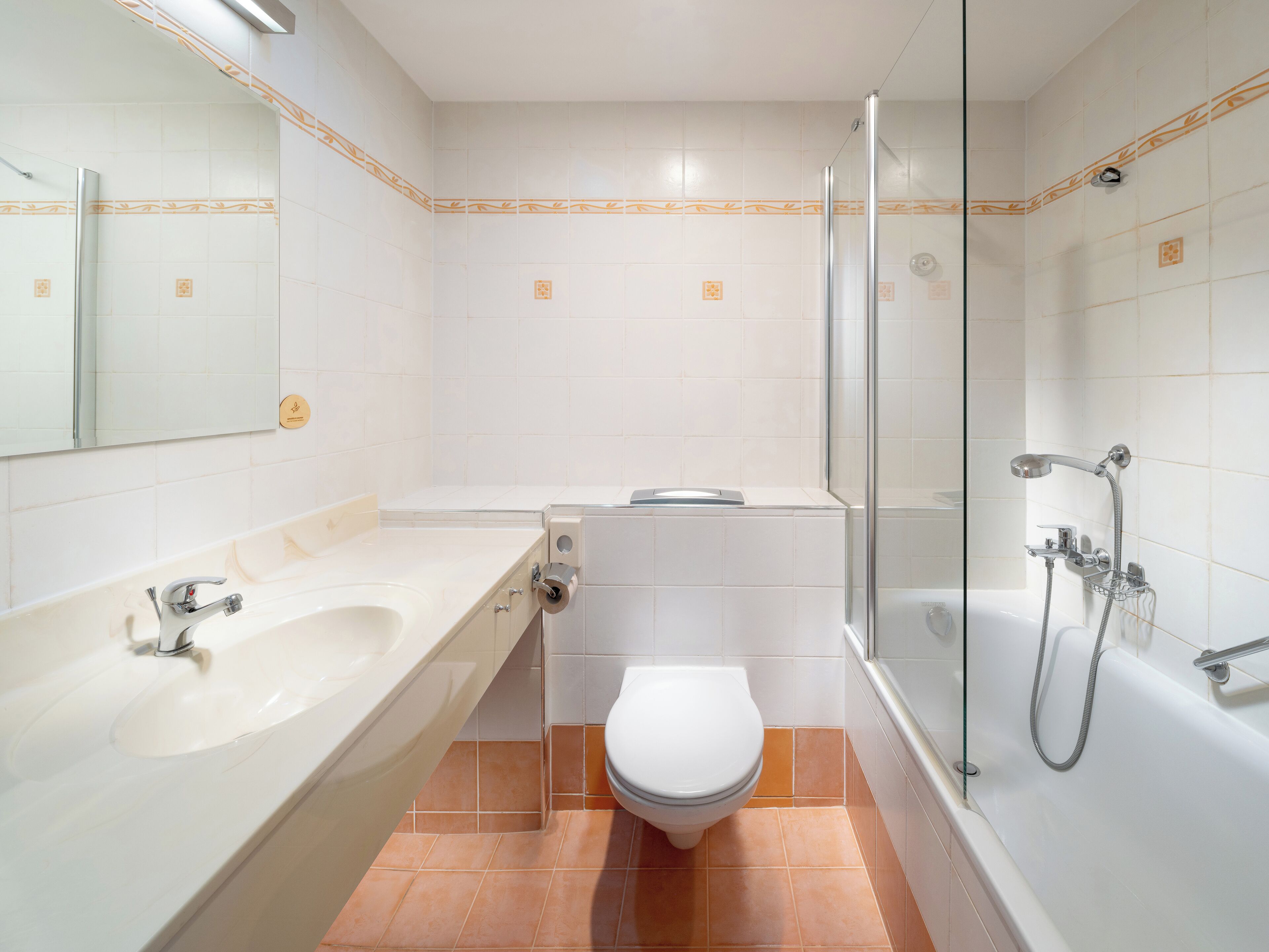 A modern bathroom with a bathtub, shower, and toilet.